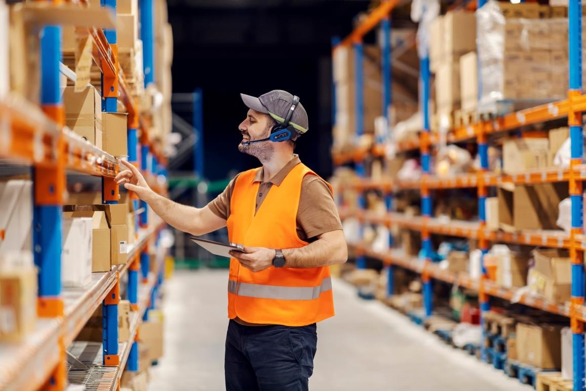 Worker picking stock from shelving in a distribution centre