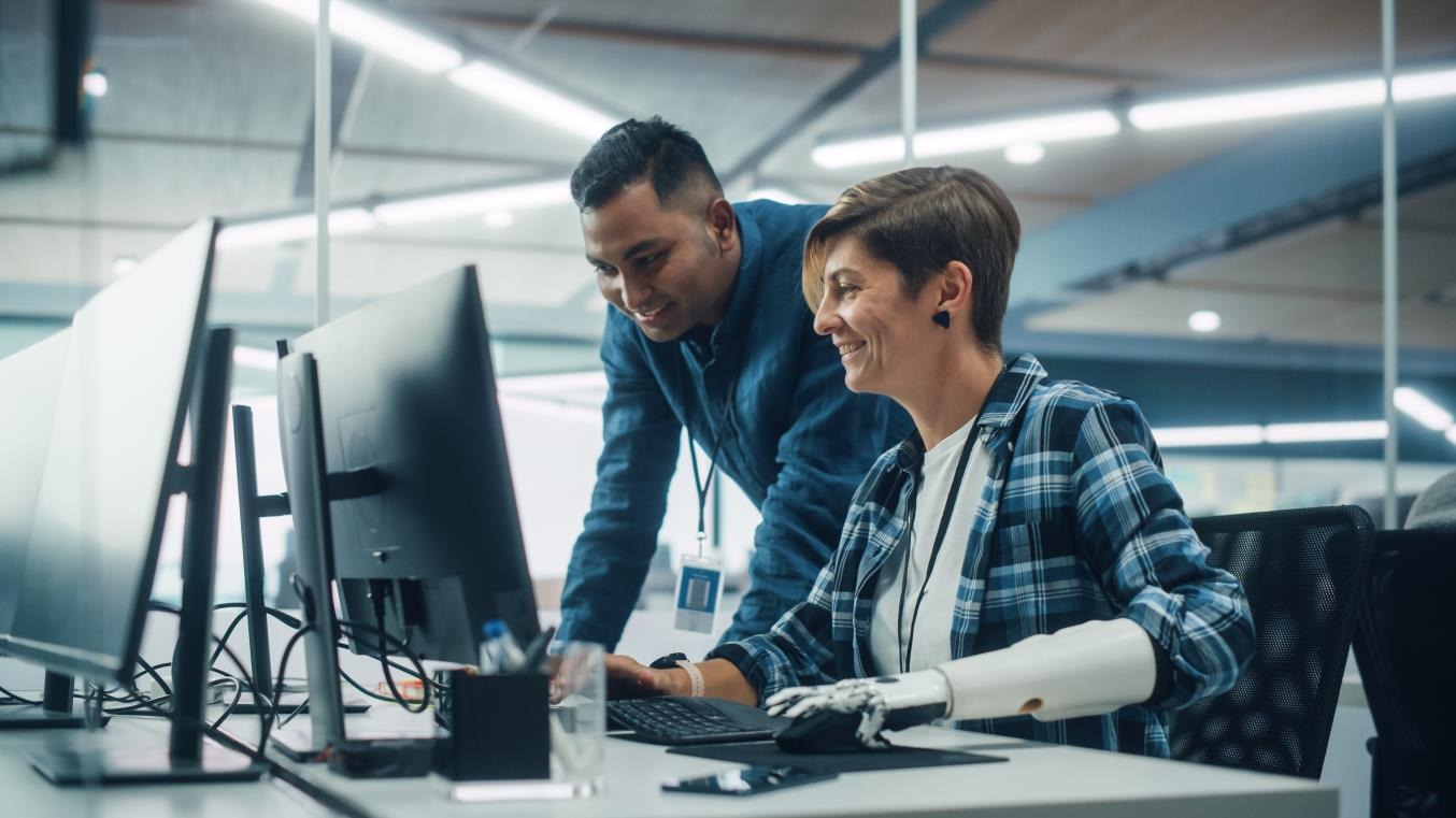 Two colleagues at a laboratory workstation reviewing equipment together